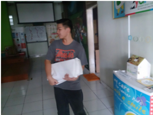 Fulgen sedang membawa satu pak buku dan brosur